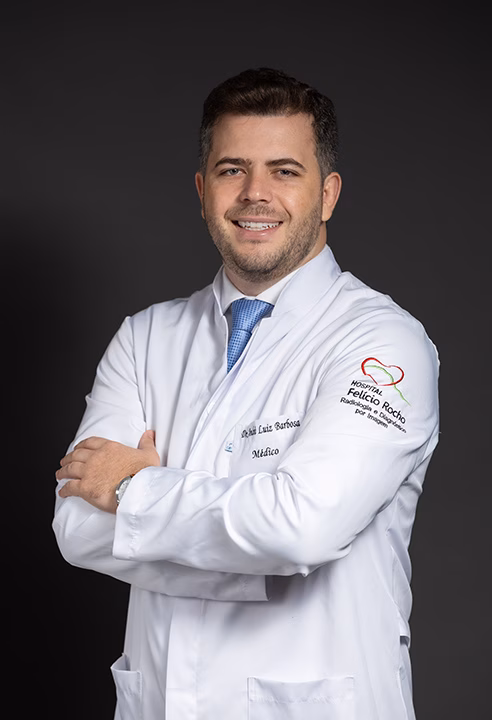 Foto de perfil profissional de médico de jaleco branco, sorrindo, feita no estúdio em BH
