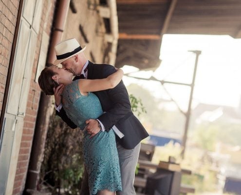 Hochzeitspaar küsst sich innig auf einer alten Laderampe, eins der coolsten Hochzeitsshootings des vergangenen Jahres...