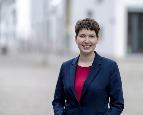 freundliches Businessportrait vor heller Fassade fotografiert in Erfurt mit der Canon EOSR6 & RF 85mm f/1.2L USM