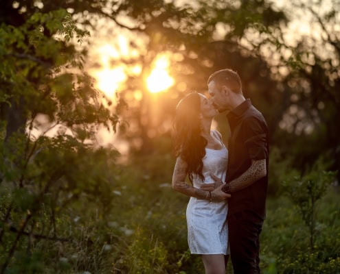 Pärchenfotoshooting im Grünen gegen die untergehende Sonne fotografiert mit der Canon EOS R6m2 & dem RF 85mm f1.2 bei Blende 1.2