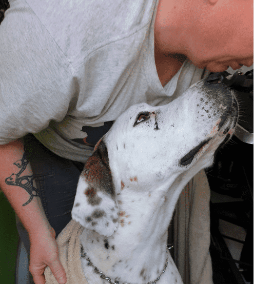 man resting chin on dogs nose