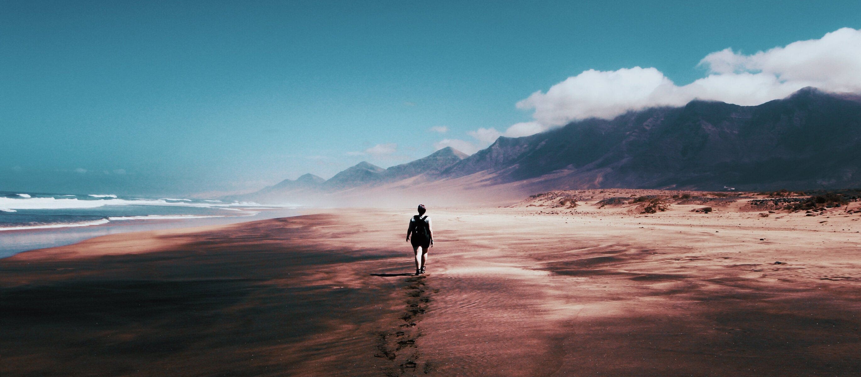 Woman walking alone on a beach