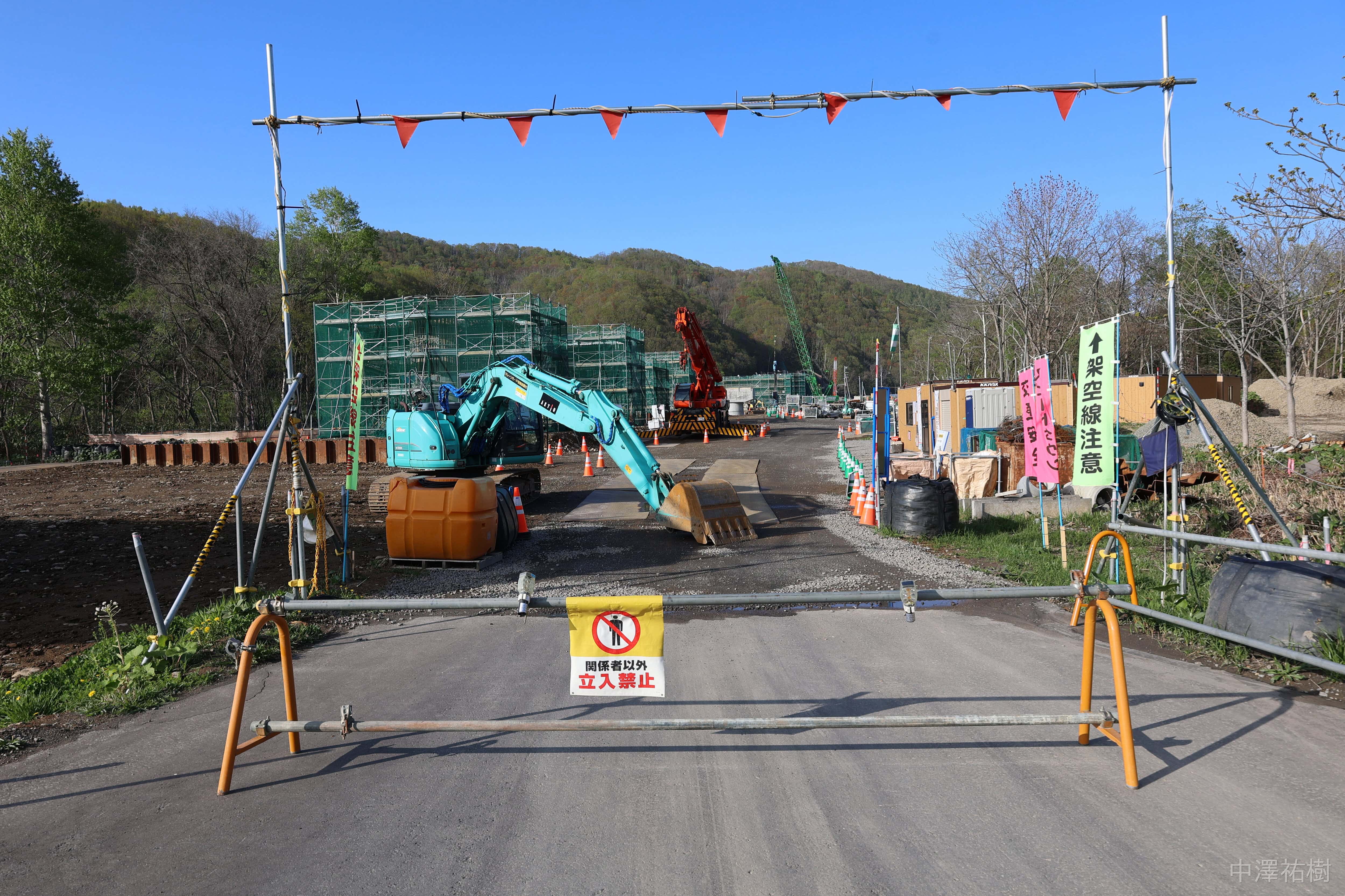 道路沿いから見た入り口と工事中の橋脚