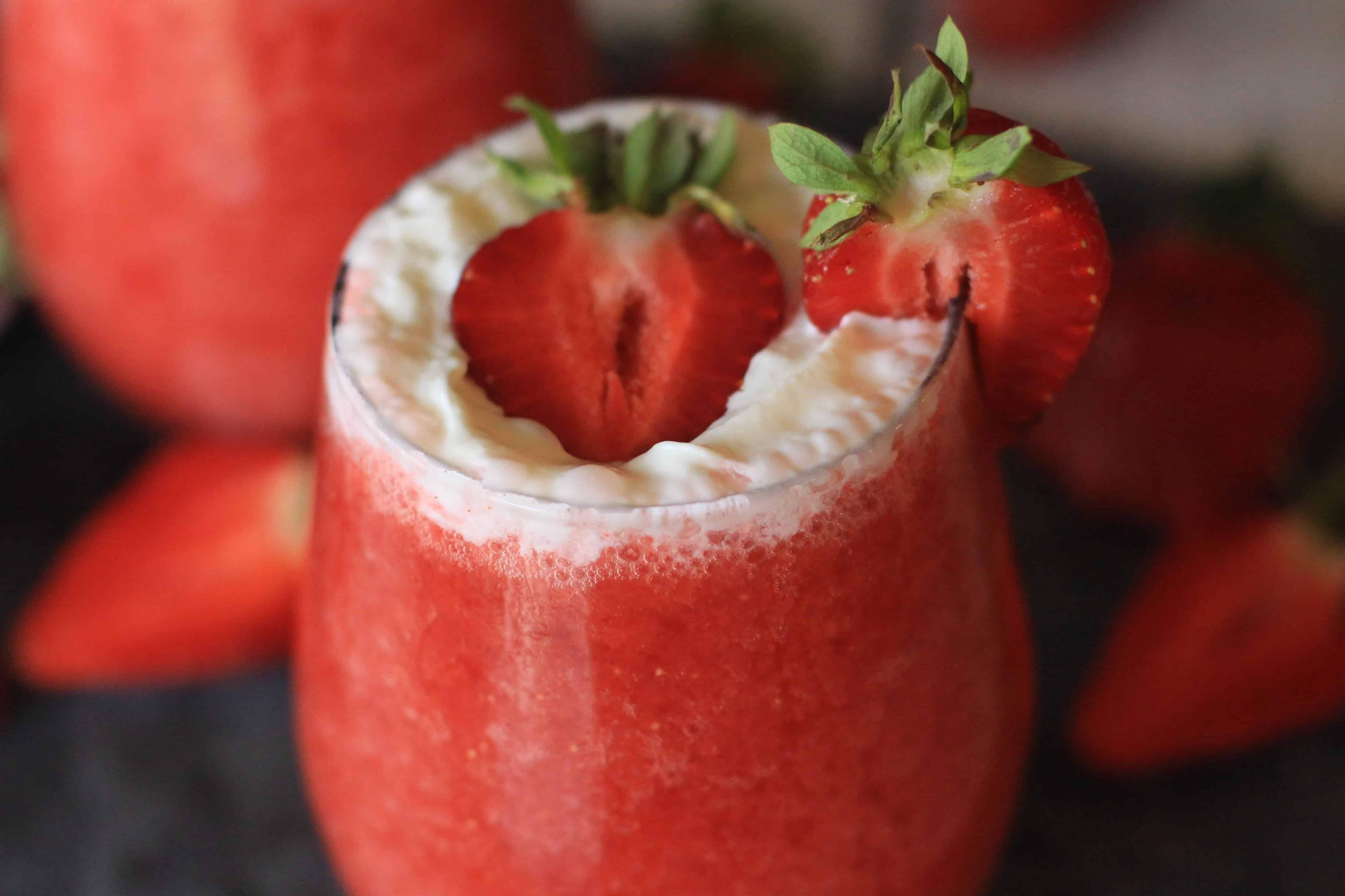 Cheers to Strawberry season. With just a few simple ingredients, you can make your own Strawberry Shortcake Daiquiris at home. Skip the mix and make fresh strawberry daiquiris at home using this easy recipe. It's the perfect slushy cocktail for cooling down in warmer weather! #strawberrydaiquiri #cocktails #slush