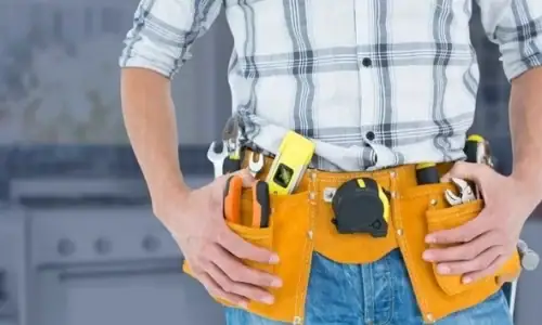 Common handyman homeowners need fixing a kitchen cabinet in a modern home.