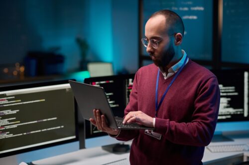 employee typing on laptop to install business antivirus