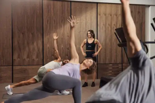 Personal trainer leading a boutique group fitness class with participants performing guided strength and mobility exercises in a wellness studio in a Raleigh apartment gym.