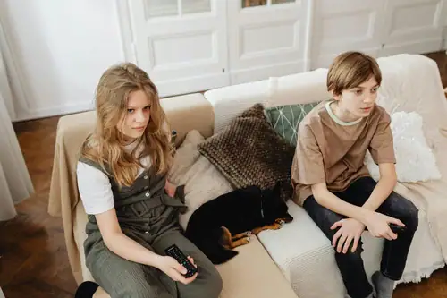 Two teens sitting on sofa with dog, child emotional needs and attention‑seeking