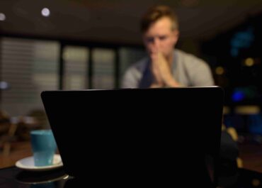 Worried Man Working on his Laptop at Night
