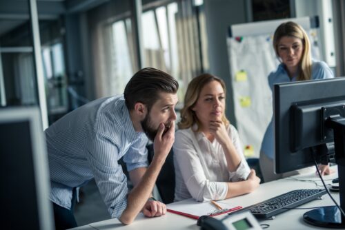 team looking at computer figuring out zero trust solutions
