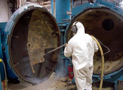 Technician using silo blasting solutions on industrial equipment