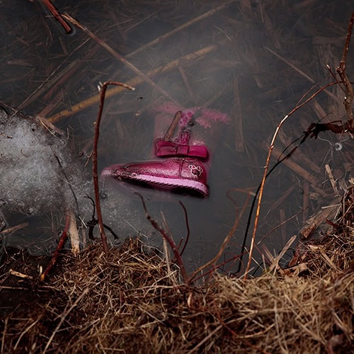 A child's boot in a pond