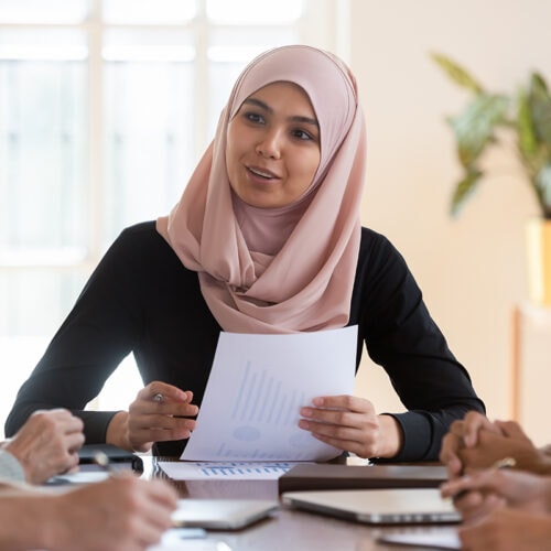 Candid picture of a business team collaborating. Filtered with light flares and cool tones.