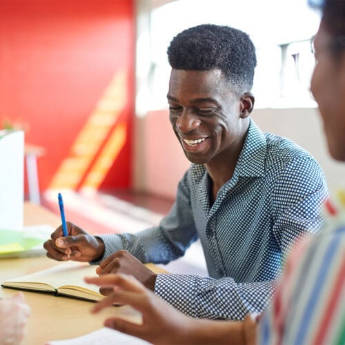 Candid picture of a business team collaborating. Filtered with light flares and cool tones.