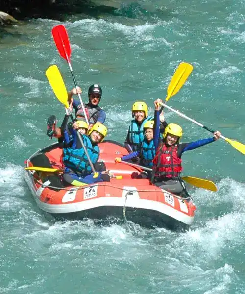 sur le raft tout le monde sourit et leve sa pagaie