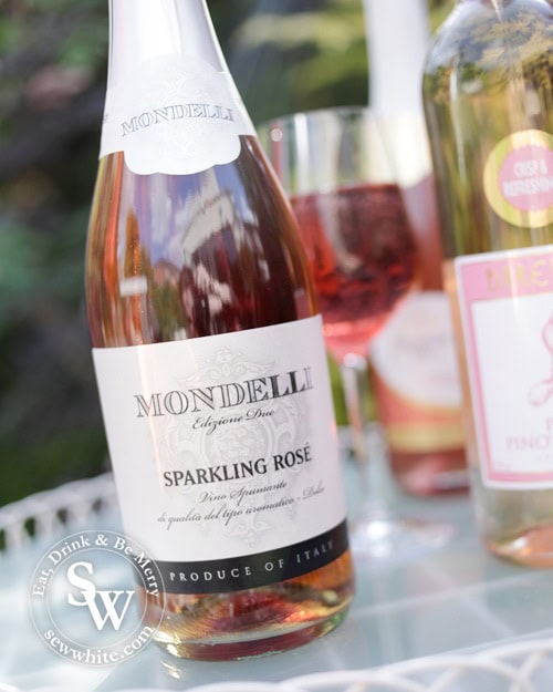 Mondelli sparkling Rose bottle on a garden table