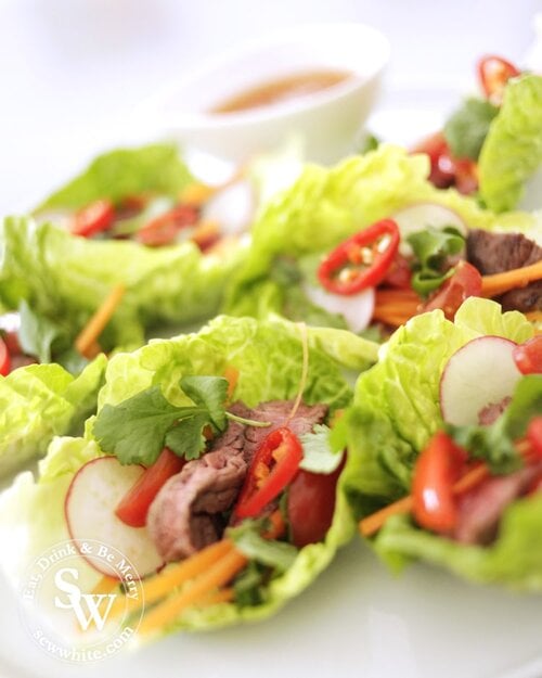 Vietnamese lettuce wraps filled with steak, raddish, chilli and carrots with spicy dipping sauce