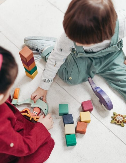 kindergarden kids playing with toys on the floor. childcare centres need extra care when it come to provide a clean facility