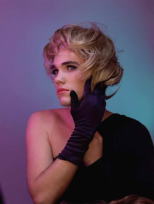 Transgender hair loss - A transgender woman in black gloves admiring with her hair reflection in the mirror.