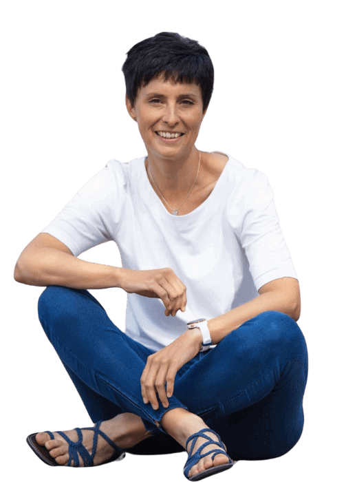 uniquewebdesigns - Kerstin Butz sitzt im Schneidersitz und lächelt – Webdesignerin für empathische Webseiten