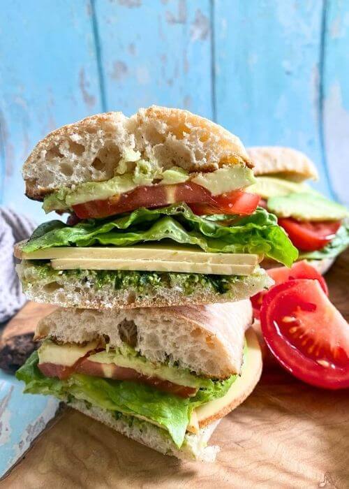 cheese, avocado and tomato sandwich on a wooden board, on a blue wood background