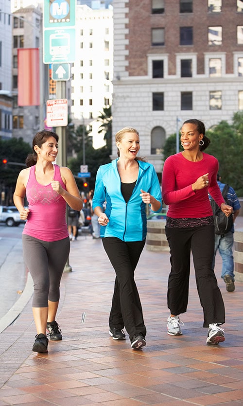 Group Of Women Power Walking On Urban Street