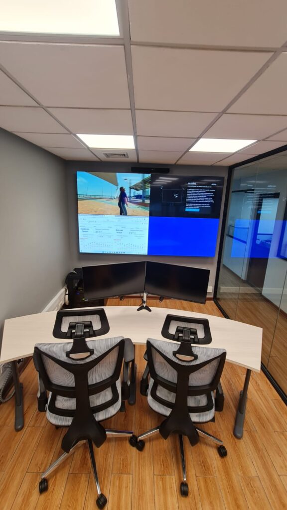 Video Wall de 2x2 pantallas activas en sala de monitoreo de Abastible, con estaciones de trabajo dobles y mobiliario ergonómico