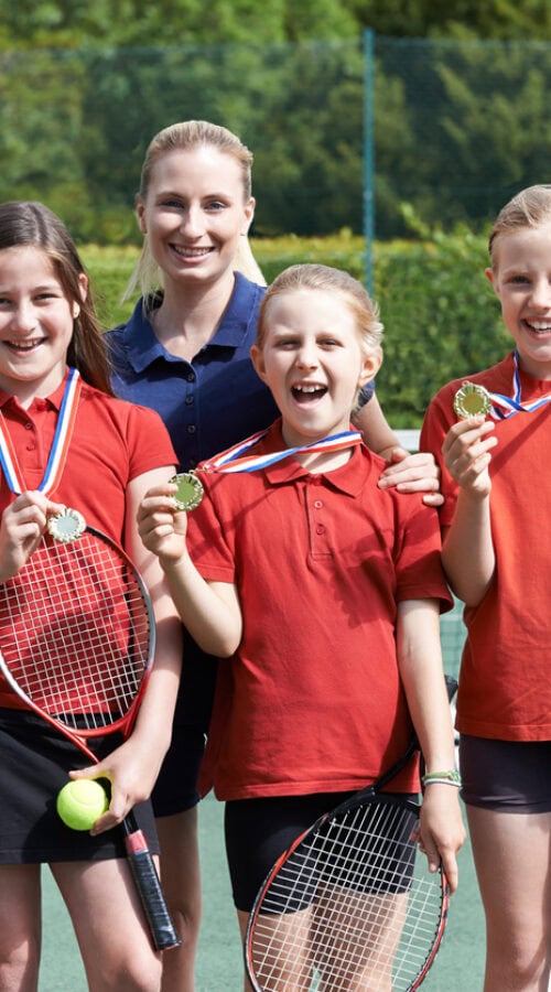 Portrait Of Winning School Tennis Team With Medals