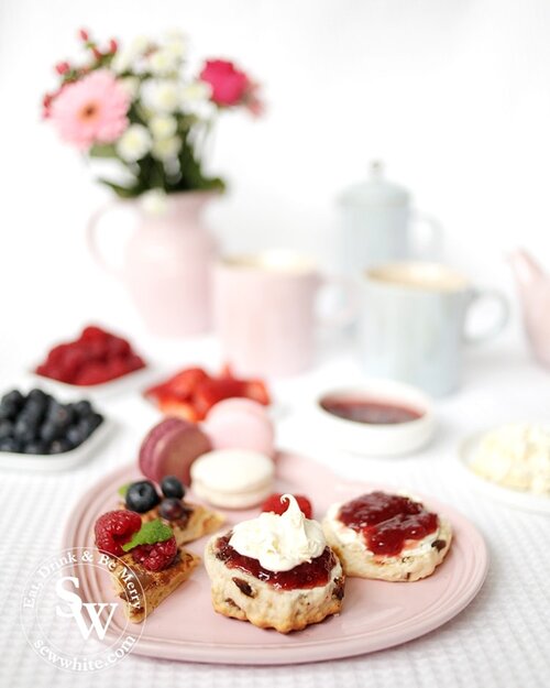 Afternoon Tea Fruit Scones made with sultanas and served on a Le Creuset heart plate with clotted cream and jam.