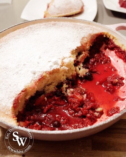 The summer fruit sponge pudding served revealing the red berries under the golden brown sponge.