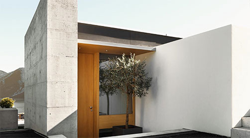 Sleek modern residential house with minimalist concrete and wood elements.