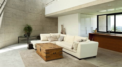 Modern living room with concrete walls and minimalist decor.