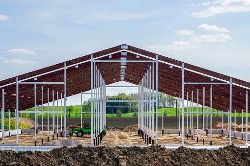 Red steel-frame farm barn in a Canadian field