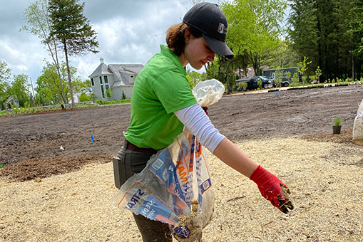landmark landscapes employee spreading grass seed