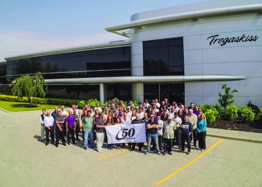 Employees in front of Tregaskiss holding 50th anniversary sign