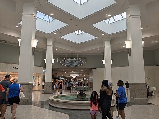 Interior of Melbourne Square Mall showing shops, central fountain, and shoppers on the Space Coast