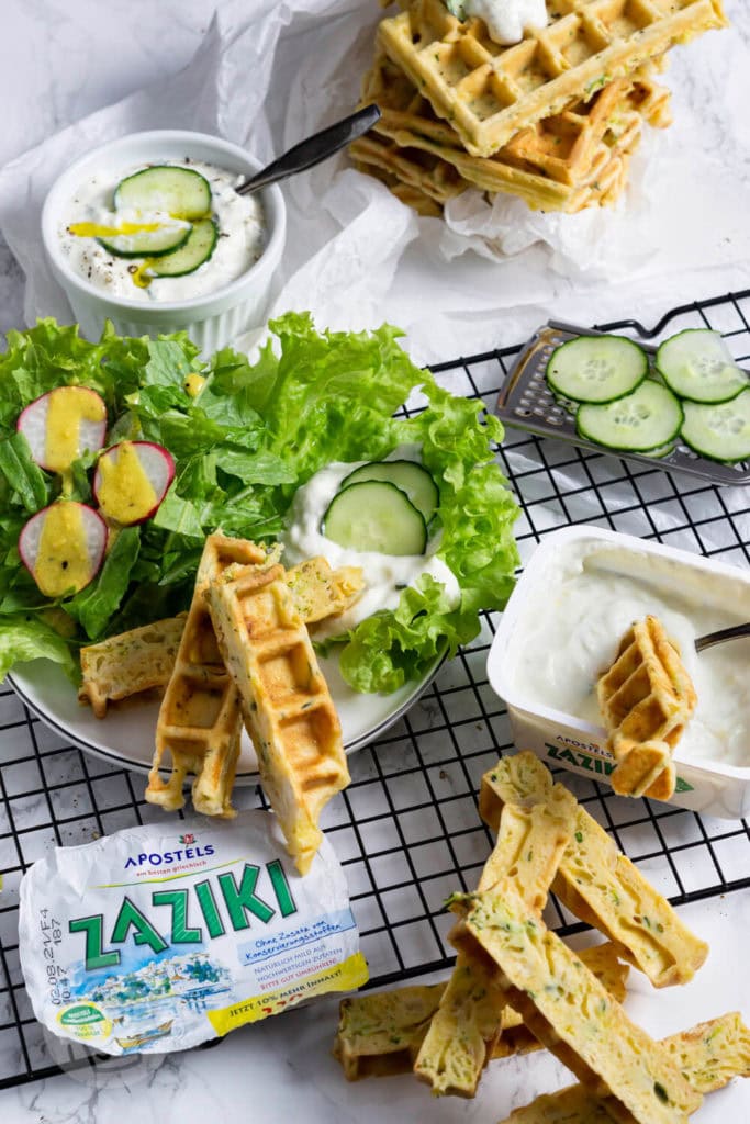 Zucchiniwaffeln mit Zaziki 5 Zucchiniwaffeln in Streifen geschnitten mit Zaziki, Salatblättern und Gurkenscheiben angerichtet