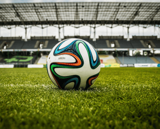Soccer ball with colorful design on a stadium field for sports events.