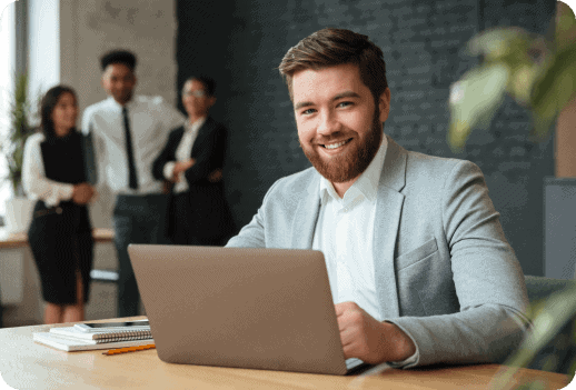 Business professional working on a laptop in a modern office setting.