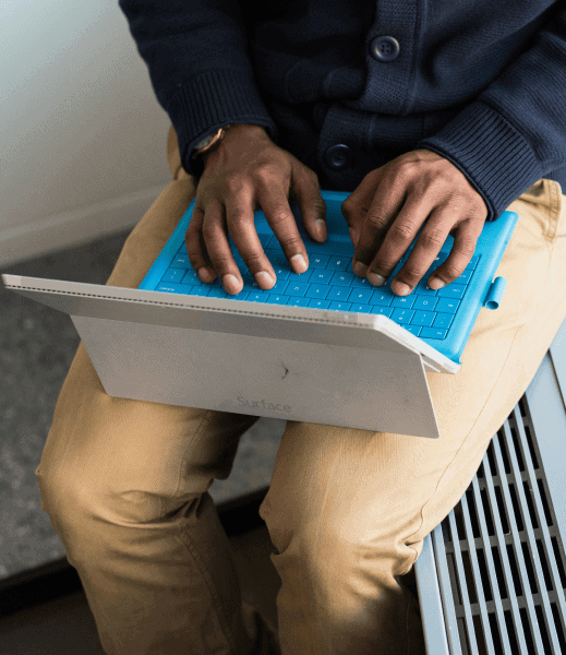 Hands of a person typing on a laptop.