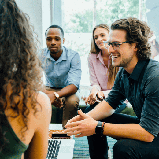 A team meeting where everybody is looking at a laptop.