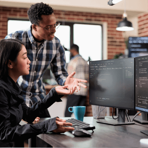 Two people looking at data at a computer screen.
