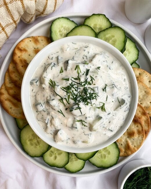 Healthy Five Minute Tzatziki in a bowl with cucumbers and crackers