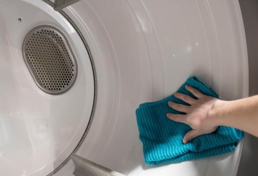 a woman cleaning the inside of a washing machine