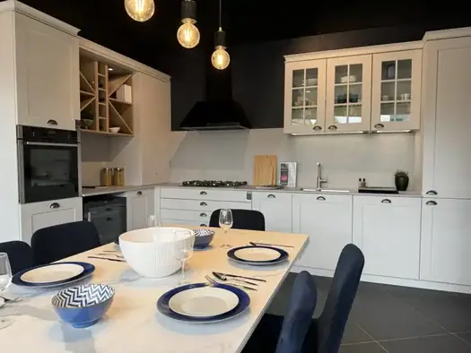 White shaker kitchen design with dining table by Schmidt Swansea