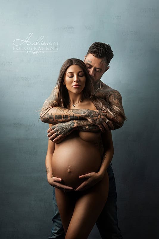 Elegant gravidfotografering med gravid kvinne og partner, som viser kjærlighet og forventning. Profesjonell gravidfoto i studio for å fange spesielle graviditetsøyeblikk.