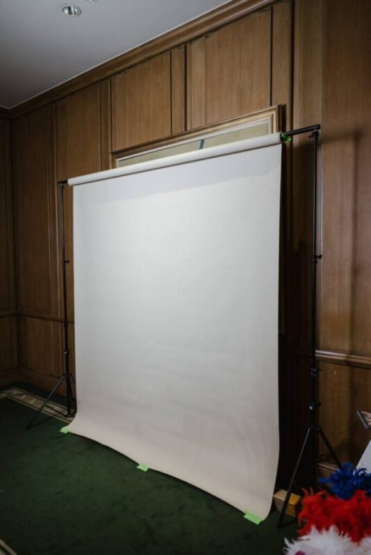 White seamless studio backdrop set up for the photo booth in a wood-panelled ballroom