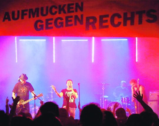 Foto eines Konzertes gegen Rechts in einem Mehrgenerationenhaus in Mühlhausen. Es ist die Bühne mit den Musikern zu sehen, die gerade Live spielen.