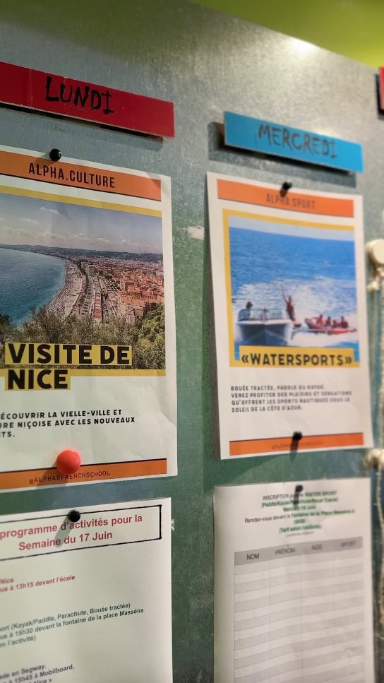 Anschlagtafel mit Aktivitäten einer Sprachschule, darunter eine Stadtführung in Nizza und Wassersport.