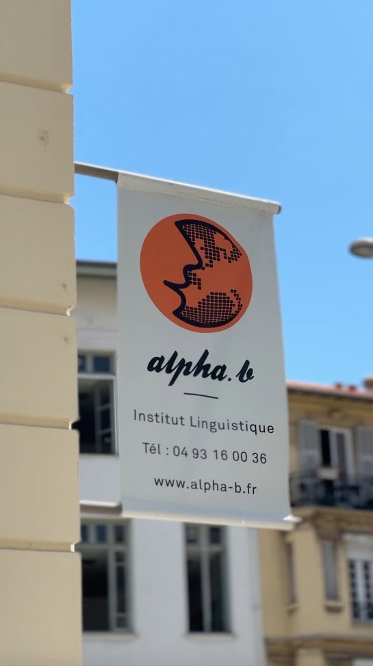Schild der Alpha.b Sprachschule in Nizza mit Logo und Kontaktdaten.